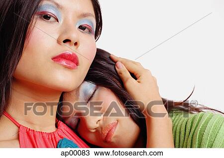 Woman looking at camera, another woman leaning on her shoulder, eyes closed View Large Photo Image Stock Image - Woman looking at camera, another woman leaning on her shoulder, eyes closed. Fotosearch