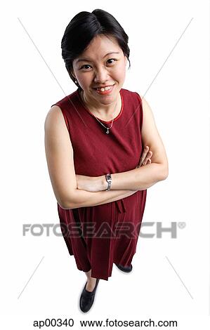 Stock Image - Woman looking at camera, arms crossed. Fotosearch