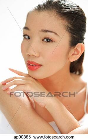 Stock Photography - Woman looking at camera, hand on chin. Fotosearch
