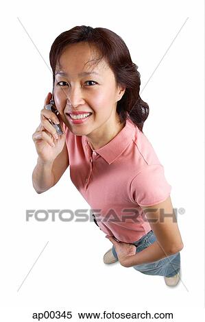 Stock Photography - Woman looking at camera, holding mobile phone. Fotosearch