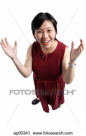 Stock Image - Woman looking at camera, smiling, hands raised. Fotosearch
