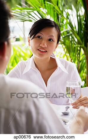 Woman looking at man sitting across table from her View Large Photo Image Stock Photograph - Woman looking at man sitting across table from her. Fotosearch