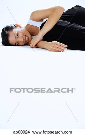 Picture - Woman lying on side, looking at camera, portrait. Fotosearch