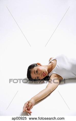 Stock Photography - Woman on back, arm outstretched, looking at camera. Fotosearch