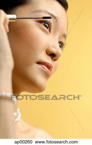 Woman putting on mascara View Large Photo Image Stock Image - Woman putting on mascara. Fotosearch
