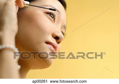 Woman putting on mascara View Large Photo Image Stock Image - Woman putting on mascara. Fotosearch