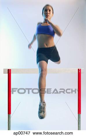 Woman running and jumping over hurdle View Large Photo Image Stock Photo - Woman running and jumping over hurdle. Fotosearch
