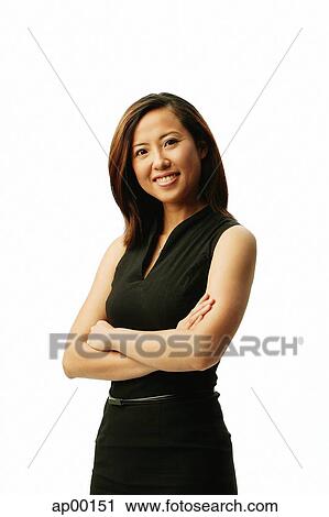 Stock Image - Woman smiling at camera, arms crossed, portrait. Fotosearch