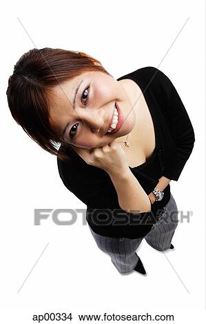 Woman standing, hand on chin, looking up at camera View Large Photo Image Picture - Woman standing, hand on chin, looking up at camera. Fotosearch