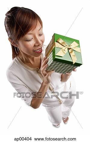 Picture - Woman standing, holding gift. Fotosearch