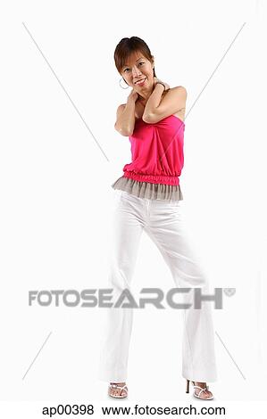 Stock Photo - Woman standing, looking at camera. Fotosearch