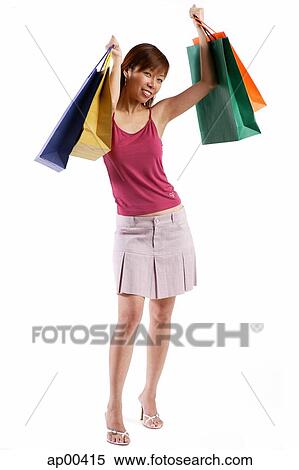 Woman standing, raising shopping bags View Large Photo Image Stock Photography - Woman standing, raising shopping bags. Fotosearch