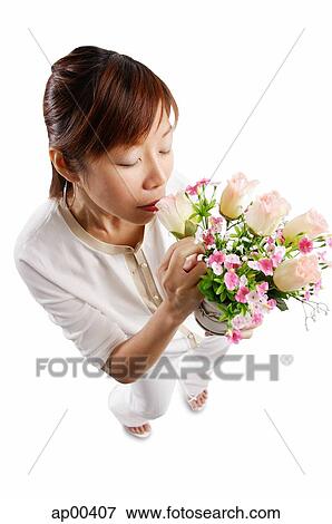 Woman standing, smelling bouquet of flowers View Large Photo Image Stock Photo - Woman standing, smelling bouquet of flowers. Fotosearch