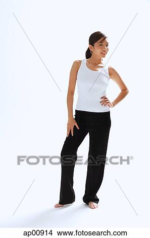 Picture - Woman standing with hands on hip, looking at camera. Fotosearch