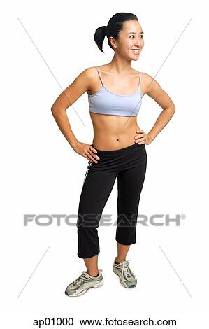 Stock Image - Woman standing with hands on hips, looking away. Fotosearch