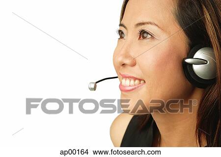 Woman using headset, looking away, portrait View Large Photo Image Picture - Woman using headset, looking away, portrait. Fotosearch