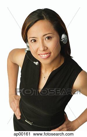 Woman using headset, smiling up at camera View Large Photo Image Stock Image - Woman using headset, smiling up at camera. Fotosearch
