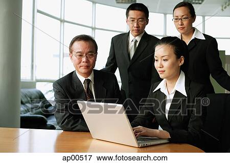 Woman using laptop, other executives around her watching View Large Photo Image Stock Photo - Woman using laptop, other executives around her watching. Fotosearch