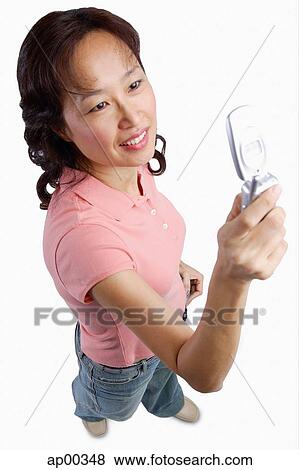 Stock Photo - Woman using mobile phone, text messaging. Fotosearch