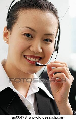 Stock Photo - Woman wearing headset, looking at camera. Fotosearch