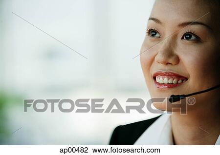 Stock Image - Woman wearing headset, portrait. Fotosearch