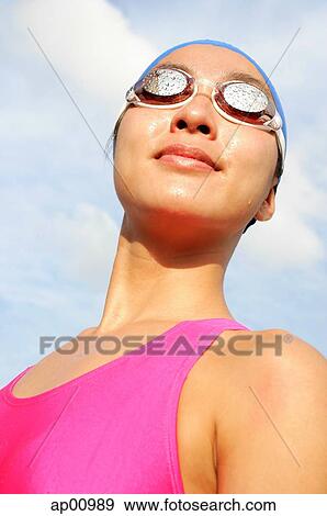 Woman wearing swimming goggles, smiling, looking away, head shot View Large Photo Image Stock Photo - Woman wearing swimming goggles, smiling, looking away, head shot. Fotosearch