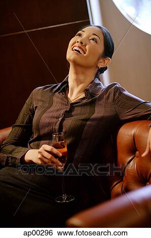 Woman with champagne glass, looking up, smiling View Large Photo Image Stock Photograph - Woman with champagne glass, looking up, smiling. Fotosearch