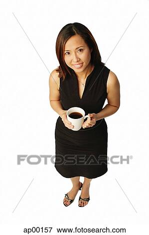Stock Photo - Woman with coffee cup, looking up at camera. Fotosearch