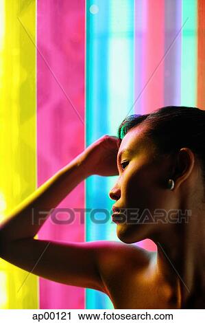 Woman with hand on head, leaning against coloured glass View Large Photo Image Stock Image - Woman with hand on head, leaning against coloured glass. Fotosearch