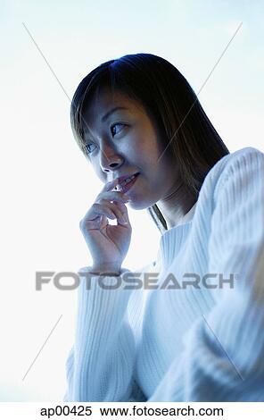 Stock Photography - Woman with hand on mouth, looking away. Fotosearch