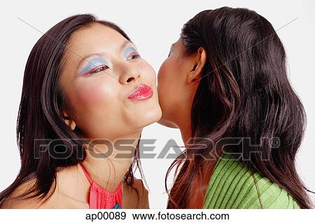 Stock Photo - Woman with mouth puckered, kissing other woman. Fotosearch