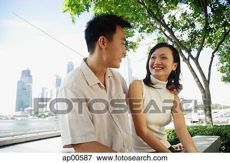 Stock Photo - Young couple sitting and looking at each other. Fotosearch