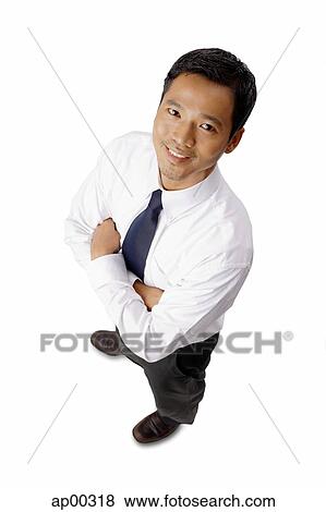 Young executive, arms crossed, smiling at camera View Large Photo Image Stock Photo - Young executive, arms crossed, smiling at camera. Fotosearch