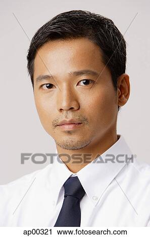 Stock Image - Young executive, looking at camera, portrait. Fotosearch