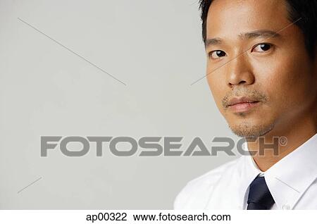 Stock Image - Young executive, looking at camera. Fotosearch