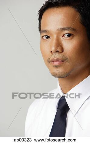 Stock Image - Young executive, looking at camera, portrait. Fotosearch