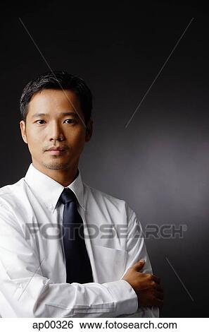 Young executive, looking at camera, arms crossed View Large Photo Image Stock Photograph - Young executive, looking at camera, arms crossed. Fotosearch