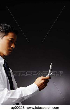 Stock Photo - Young executive, using mobile phone. Fotosearch