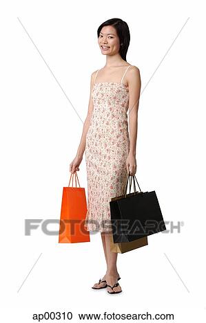 Young woman carrying shopping bags, smiling at camera View Large Photo Image Stock Image - Young woman carrying shopping bags, smiling at camera. Fotosearch