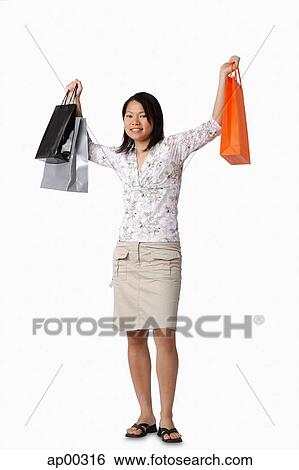 Stock Photograph - Young woman carrying shopping bags, portrait. Fotosearch