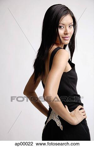 Young woman, hands on hip, looking over shoulder at camera View Large Photo Image Stock Image - Young woman, hands on hip, looking over shoulder at camera. Fotosearch