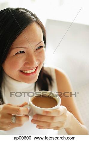 Young woman, holding cup of coffee, smiling View Large Photo Image Stock Image - Young woman, holding cup of coffee, smiling. Fotosearch
