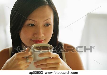 Young woman, holding cup of coffee, looking away View Large Photo Image Stock Image - Young woman, holding cup of coffee, looking away. Fotosearch