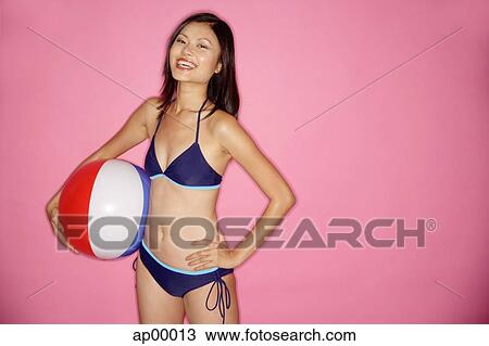 Young woman in bikini, hands on hips, holding beach ball View Large Photo Image Stock Image - Young woman in bikini, hands on hips, holding beach ball. Fotosearch