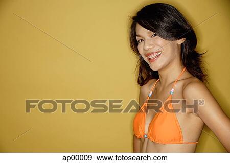 Young woman in bikini, looking at camera, smiling View Large Photo Image Stock Photo - Young woman in bikini, looking at camera, smiling. Fotosearch