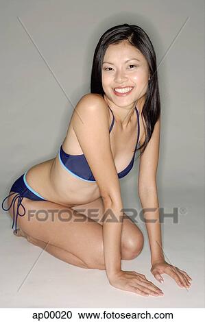 Young woman in bikini, sitting on floor, smiling at camera View Large Photo Image Stock Image - Young woman in bikini, sitting on floor, smiling at camera. Fotosearch