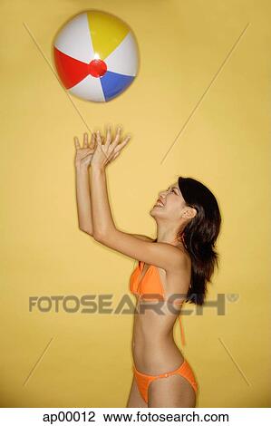 Young woman in bikini, throwing ball in air View Large Photo Image Stock Image - Young woman in bikini, throwing ball in air. Fotosearch