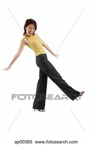 Stock Photography - Young woman kicking, looking at camera. Fotosearch