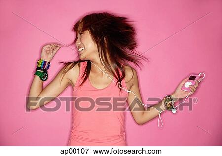 Stock Photo - Young woman listening to music, portrait. Fotosearch