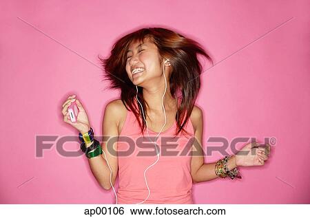 Young woman listening to music View Large Photo Image Stock Photograph - Young woman listening to music. Fotosearch